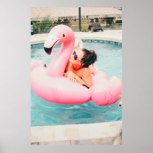 Frau auf rosa aufblasbarem Flamingo im Außenpool Poster