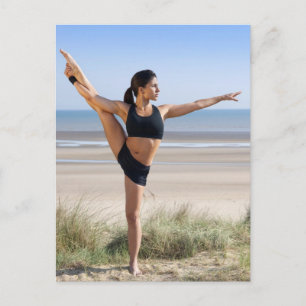 Frau, die am Strand Yoga mit sich trägt Postkarte