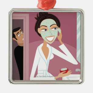 Frau, die Gesichtsmaske anwendet Silbernes Ornament