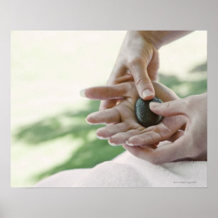 Frau, die Handmassage mit heißem Stein erhält Poster