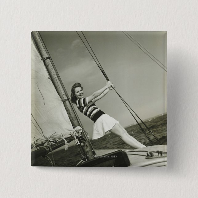 Frau, die Takelung auf Yacht hält Button (Vorderseite)
