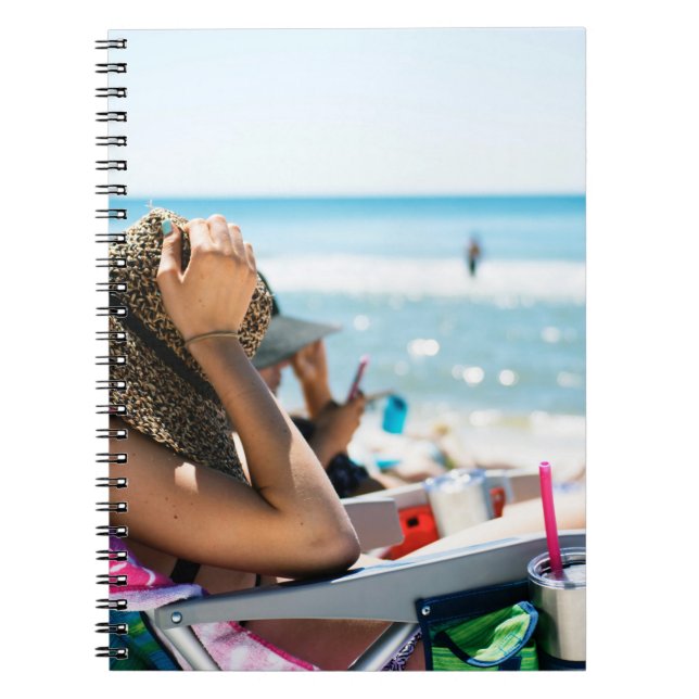 Frauen, die auf einer Sonnenliege liegen und ihr G Notizblock (Vorderseite)