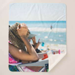 Frauen, die auf einer Sonnenliege liegen und ihr G Sherpadecke