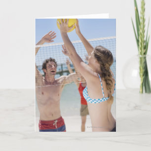 Freunde spielen Volleyball am Strand Karte