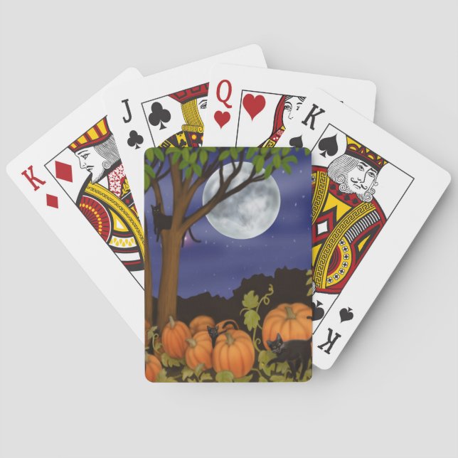 Freundliche schwarze Katzen im Kürbispatch spielen Spielkarten (Rückseite)