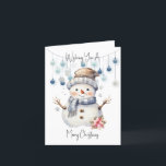 Frohe Weihnachten Snowman<br><div class="desc">Wünschen Sie jemandem ein besonderes Weihnachten mit dieser bezaubernden Karte. Ein bezaubernder Aquarellschneemann mit Hut und Schal und einem großen, fröhlichen Lächeln. Hinter ihm hängen einige blaue Bausteine an einer Kette. Oben und unten liest Wünscht Ihnen ein frohes Weihnachtsfest in einem schwarzen Skript.</div>