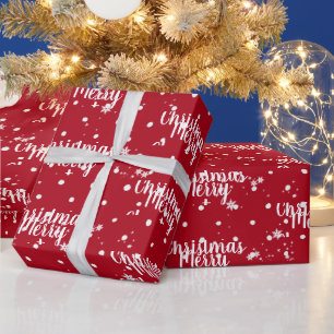 Fröhlicher Weihnachtstext in Schneeflocken auf rot Geschenkpapier