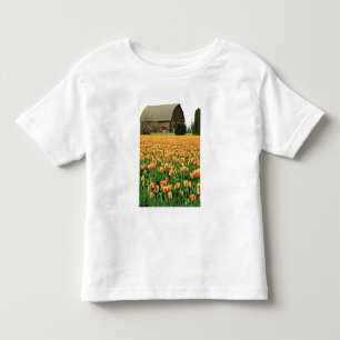 Frühlings-Tulpen blühen vor alter Scheune. Kleinkind T-shirt