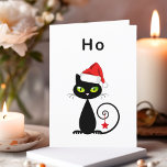 Funny Black Sitting Weihnachtskatze Weihnachtsmann Feiertagskarte<br><div class="desc">Zeigt eine schwarze Katze mit grünen Augen und lockigem Schwanz. Die Katze trägt einen roten Weihnachtsmütze und hat einen Weihnachtssternschmuck, der von ihrem Schwanz hängt. Der Text oben lautet "Ho", was ein unenthusiastischer "ho ho ho ho ho" ist. Personalisieren und personalisieren Sie den Insider-Text, der lautet: "Mann, es war schwer....</div>