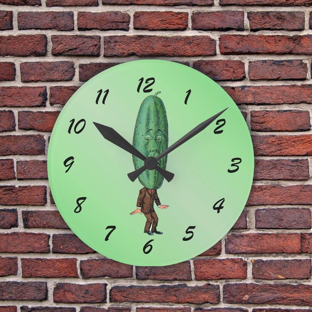 Funny Pickle Head Man trägt Anzug Runde Wanduhr (Fun man in suit with big green pickle head with a face on a light green round wall clock.)