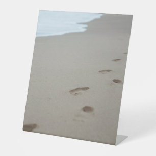 Fußabdrücke an einem weißen Strand in Mosambik Sockelschild