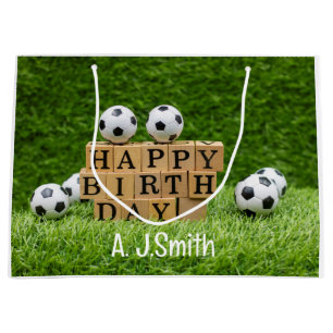 Fußball Geburtstag mit Bälle auf grünem Gras Große Geschenktüte