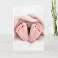 Füße eines Babymädchens mit einer weißen Margerite