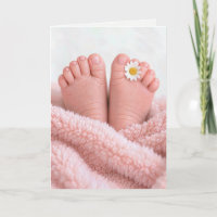 Füße eines Babymädchens mit einer weißen Margerite