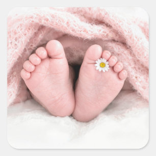 Füße eines Babymädchens mit einer weißen Margerite Quadratischer Aufkleber