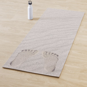 Fußspuren im Sandstrand Yogamatte