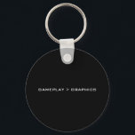 Gameplay > Grafik. Schwarz-weiß. Schlüsselanhänger<br><div class="desc">Ein einfaches Schwarz-Weiß-Design,  das "Gameplay > Grafik" sagt. Wenn Sie glauben,  dass das Gameplay in Videospielen wichtiger ist als die Grafik,  dann könnte das für Sie das Richtige sein.</div>