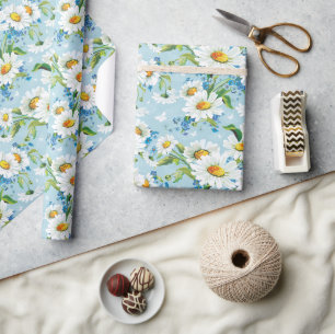 Gänseblümchen auf blauem glänzendem Geschenkpapier