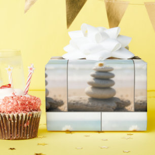 Gänseblümchen auf einem Steinstrandsteinhaufen mit Geschenkpapier