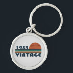 Geboren 1983 Vintager Geburtstag Schlüsselanhänger<br><div class="desc">Mit diesem originellen, 1983 in Retro-Look gestalteten Geburtstagsdesign mit phantastischen Farbtönen und Typografie geschriebenen Schriftart, können Sie Ihrem Kleiderschrank etwas Originalität hinzufügen. Es ist eine großartige Geschenkidee für Männer, Frauen, Ehemann, Ehefrau und einen Freund, der dieses einmalige Kunstwerk Liebe geben wird. Das phantastischste und lustigste Urlaubsgeschenk für Ihr Party zum...</div>