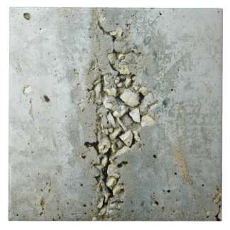 Gebrochene Betonmauer mit kleinen Steinen Fliese