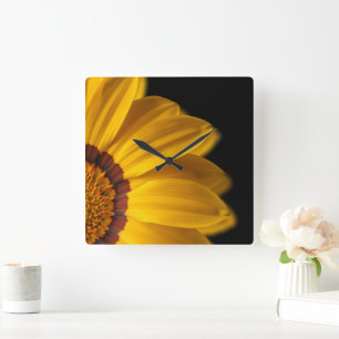 Gelbe Blume auf schwarzem Hintergrund Quadratische Wanduhr