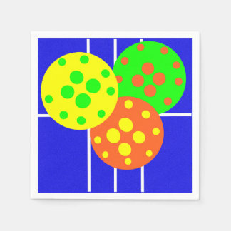 Gelbe, orangefarbene und grüne Pickleballs auf bla Serviette