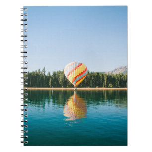 Gelbe, rote und blaue Heißluftballon in der Nähe v Notizblock