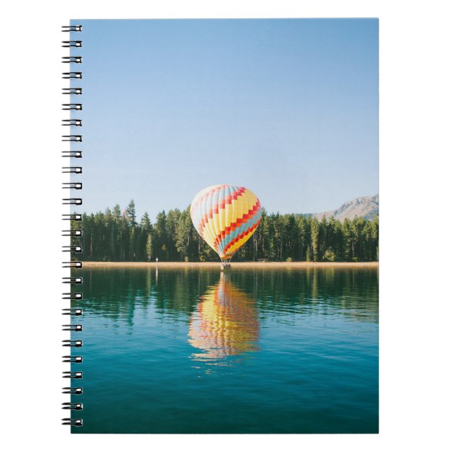 Gelbe, rote und blaue Heißluftballon in der Nähe v Notizblock (Vorderseite)