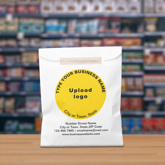 Gelbe runde Handelsmarke auf Papiertüte Geschenktütchen (Paper bag with yellow round business branding displayed in a store)