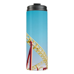 Gelbe und rote Rolle Untersetzer unter blauem Himm Thermosbecher