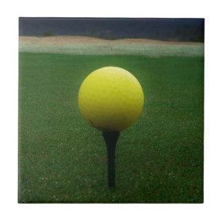 Gelber Golfball auf dem Golfplatz Fliese