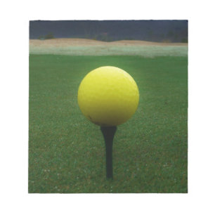 Gelber Golfball auf dem Golfplatz Notizblock