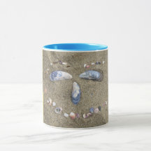 Gelbes Gesicht der Tasse gemacht im Sand mit