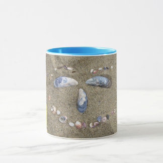 Gelbes Gesicht der Tasse gemacht im Sand mit