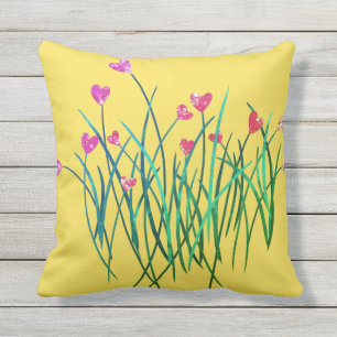 Gelbes Kissen im Freienmit Herz-Blumen