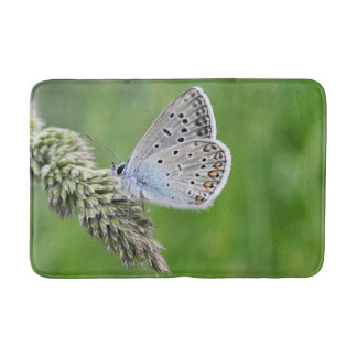 Gemeiner blauer Schmetterling auf Gras Badematte