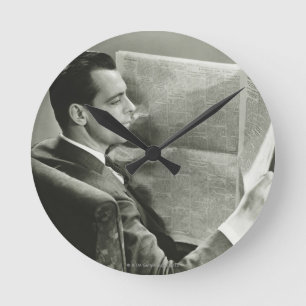 Geschäftsmann, der die Zeitung liest Runde Wanduhr