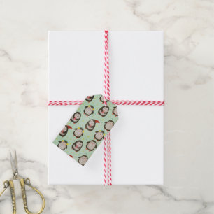 Glückliche Pinguine mit Weihnachtsmannmützen und O Geschenkanhänger