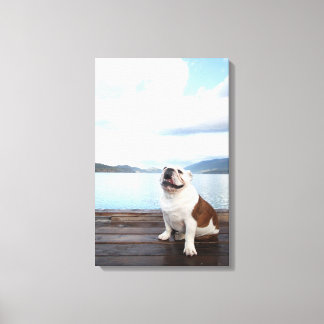 glücklicher Bullenhund sitzt auf Deck am See Leinwanddruck