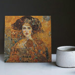 Golden Phase Gustav Klimt Mosaic Edwardian Frauen  Fliese<br><div class="desc">Diese wunderschöne Keramik-Kachel zeigt ein Kunstwerk, das von Gustav Klimts "goldener Phase" inspiriert wurde und eine Frau aus der Ära Edwards darstellt. Während dieser Zeit war Klimt von byzantinischen Mosaiken fasziniert und entwickelte seine Mosaik-Technik unter Verwendung von Blattgold und lebhaften Farben. Dieses Kunstwerk würdigt Klimts innovative Mosaik-Herangehensweise und zeigt die...</div>