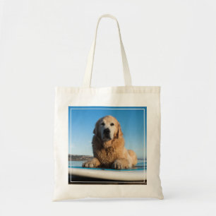 Golden retriever-Hund, der auf ein Paddel-Brett Tragetasche