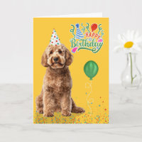 Goldendoodle-Hund mit Partyhut auf gelbem Geburtst