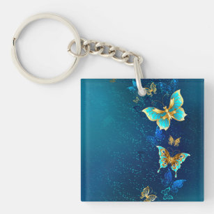Goldene Schmetterlinge auf einem blauen Hintergrun Schlüsselanhänger