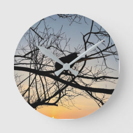 Goldene Sonnenuntergangs-Silhouette: Vogel auf Bau Runde Wanduhr