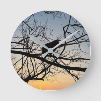 Goldene Sonnenuntergangs-Silhouette: Vogel auf Bau Runde Wanduhr