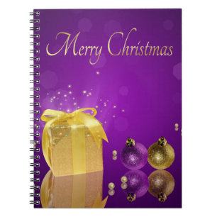 Goldene Weihnachtsgeschenkbox auf lila Lavendel Notizblock