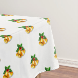 Goldene Weihnachtsglocken auf weißer Tischdecke