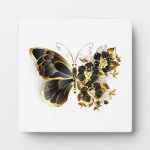 Goldener Schmetterling mit schwarzem Orchid Fotoplatte
