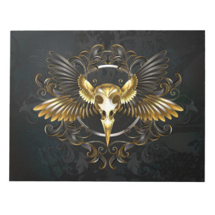 Goldener Vogelschädel auf schwarzem Hintergrund Notizblock